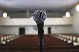 Shure sm58 microphone with church pews in the background.